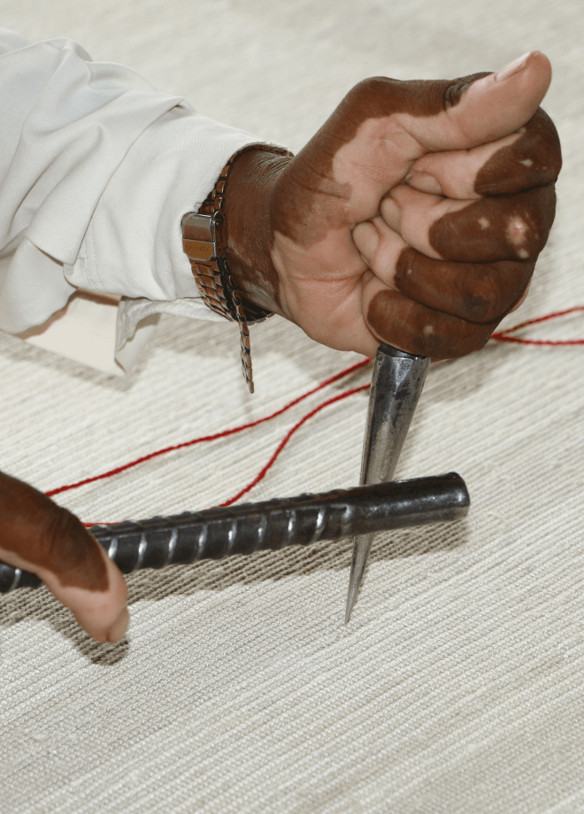 Close-up of hands working with weaving tools