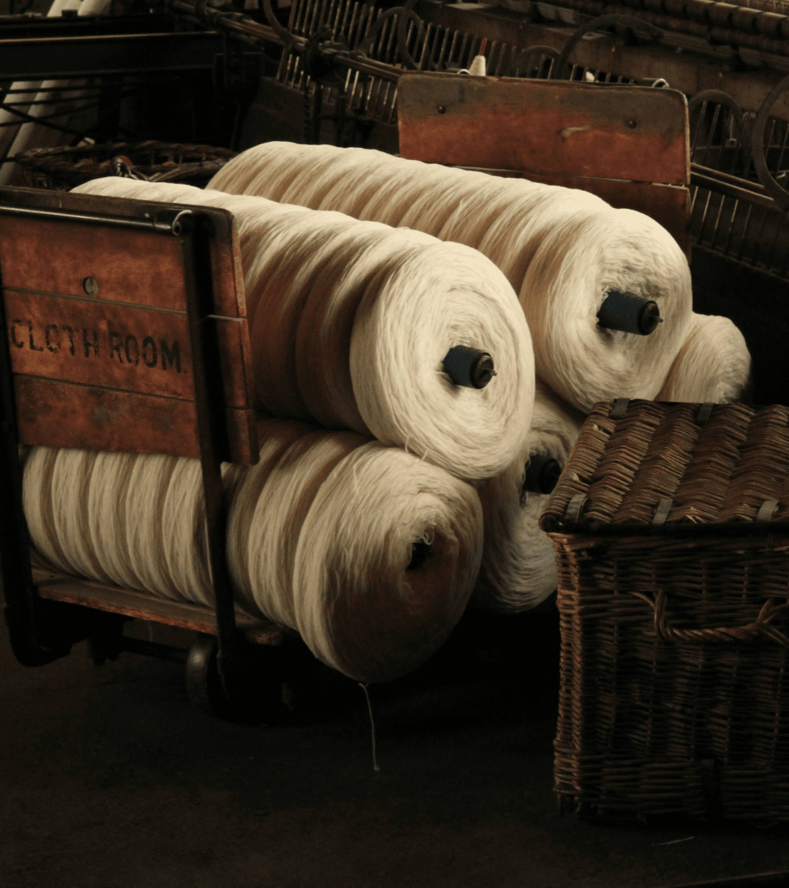 Hands working on a traditional loom with red threads